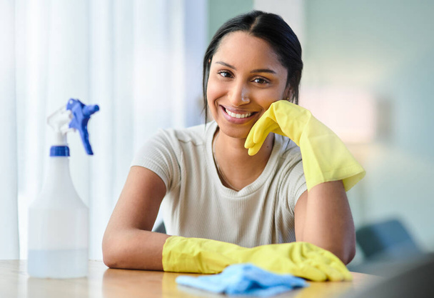 A dirty house just means youre living life right. a young woman wearing gloves at home - Foto, imagen
