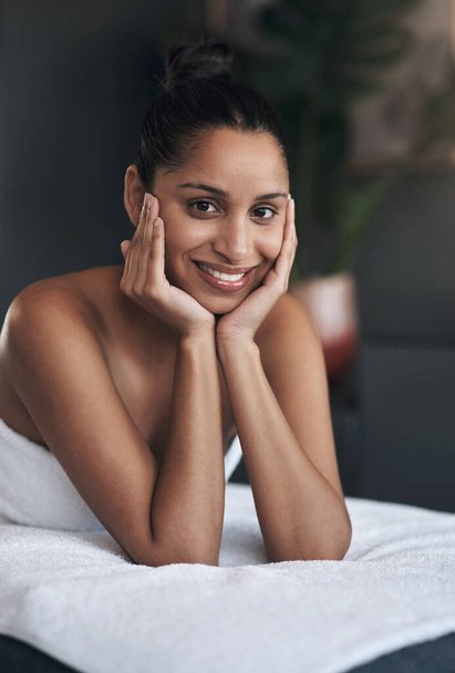 I totally love this place of bliss. Portrait of a young woman relaxing on a massage bed at a spa - Foto, Imagem