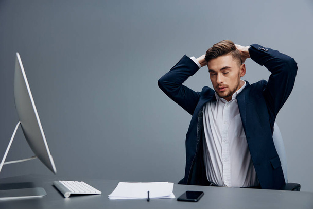 handsome businessman with phone emotions works in front of a computer isolated background. High quality photo - Photo, Image