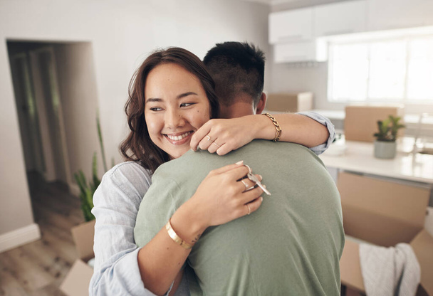 A house becomes a home when its a haven for love. a couple embracing each other while moving into their new home - Foto, afbeelding