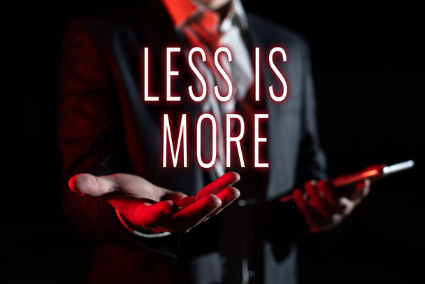 Inspiration showing sign Less Is More, Conceptual photo Minimalist approach to artistic matter is more effective Businessman In Suit Holding New Important Message In One Hand. - Fotoğraf, Görsel