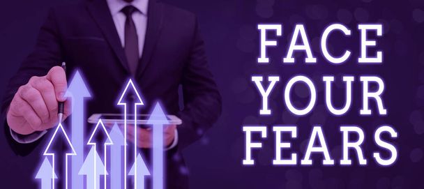 Conceptual caption Face Your Fears, Business showcase Have the courage to overcome anxiety be brave fearless Man Holding Tablet And Pen Which Points On Arrows And Presenting New Ideas. - Photo, image
