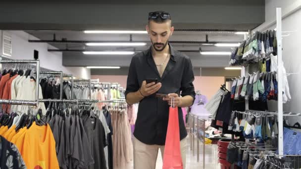 Shopping app in store, show app from phone in clothing store, show green screen in shopping store, image of shopping from the phone in the clothing aisle - Séquence, vidéo
