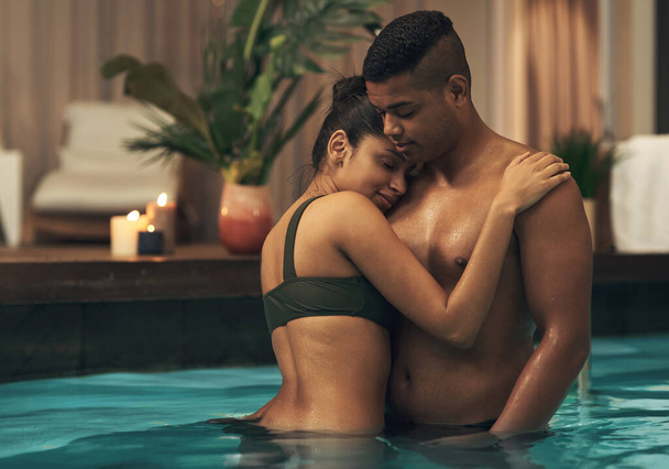 This trip brought us closer together. a young couple relaxing in a pool at a spa - Foto, afbeelding
