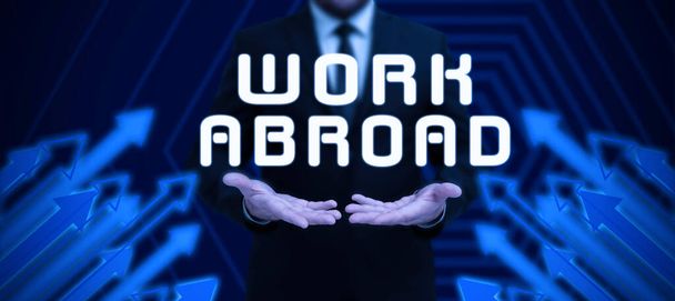 Text caption presenting Work Abroad, Business overview Immersed in a foreign work environment Job Overseas Non Local Businessman in suit holding notepad symbolizing successful teamwork. - Photo, Image
