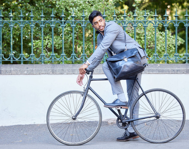 Μειώστε το αποτύπωμα άνθρακα. ένας νεαρός επιχειρηματίας καβάλα σε ποδήλατο στην πόλη - Φωτογραφία, εικόνα