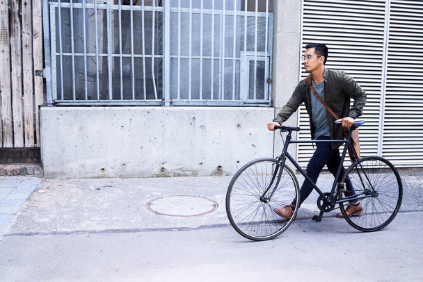 Keeping my commuting eco-friendly. a young man using a bicycle in the city - Foto, Imagem
