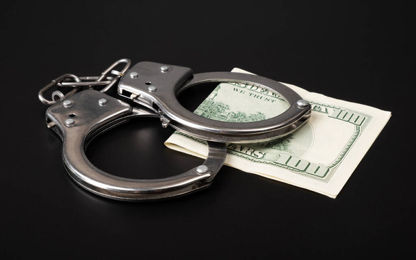 fraud and money laundering crime, handcuffs and dollars. - 写真・画像