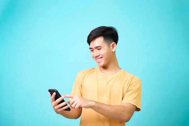 Young asian men wearing casual clothes smiling to using the phone. communication concepts. - 写真・画像