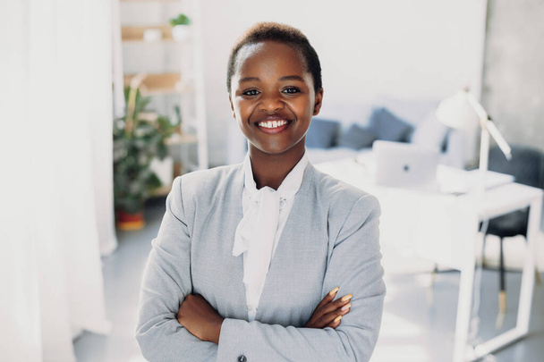 Portrait of a successful african-american business woman standing with crossed arms, looking at the camera. Beautiful young girl. Closeup portrait. Positive - Zdjęcie, obraz