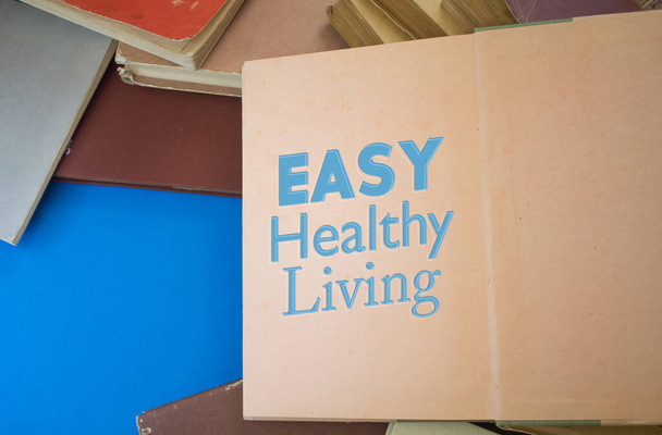 Easy Healthy Living word in opened book with vintage, natural patterns old antique paper design. - Fotó, kép