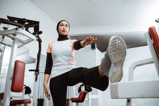 Attractive sports muslim girl smiles and stretching her body in the gym, lifestyle, healthy lifestyle. - Foto, immagini