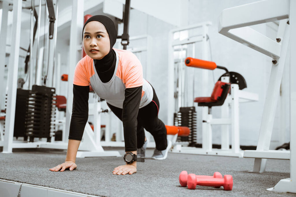 asian muslim woman doing plank push up at the gym during exercising - Fotó, kép