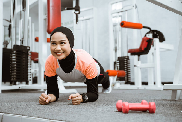 asian muslim woman doing plank push up at the gym during exercising - Foto, Imagem