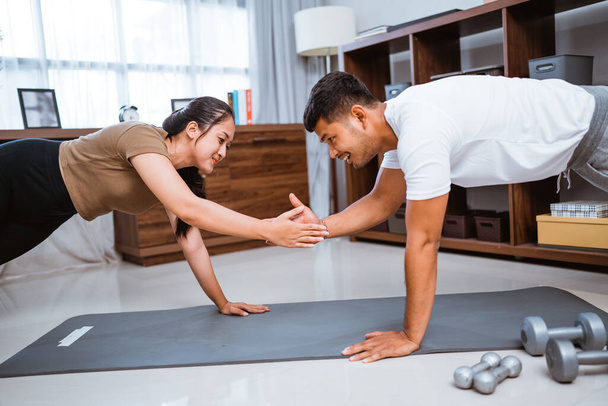 Asian fitness couple, man and woman plank exercising together at home doing partner workout facing each other - Φωτογραφία, εικόνα