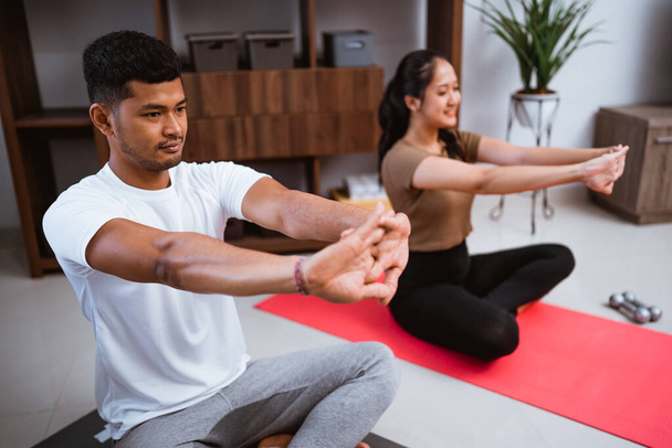 portrait of young asian couple workout together at home stretching their body - Valokuva, kuva
