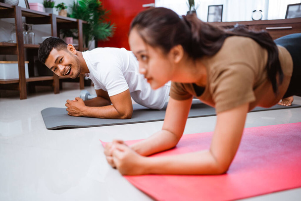Asian fitness couple planking together. man and woman exercising at home - Fotoğraf, Görsel