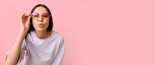 Young woman wearing stylish sunglasses on pink background with space for text - Valokuva, kuva