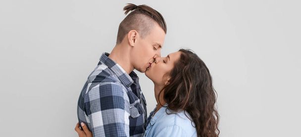 Nuori pari suutelee kevyellä taustalla
   - Valokuva, kuva