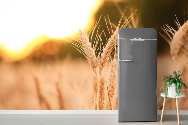 Stylish retro fridge near wall with print of wheat field - Foto, Imagem
