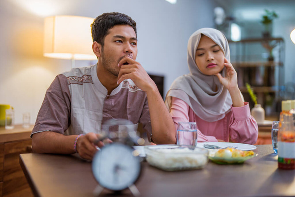 tired muslim couple wake up early to have a morning breakfast on fasting month. sahur concept in ramadan - Фото, зображення