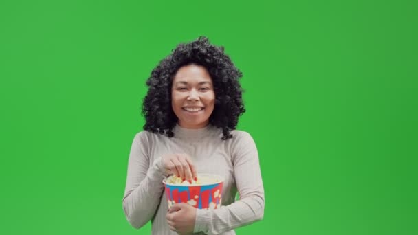 афроамериканка весела жінка, що сміється з попкорну дивиться комедію "Ізольований на зеленому екрані" - Кадри, відео