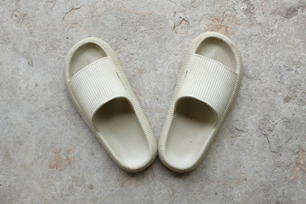 top view and flat lay a pair of slides with an open toe pillow isolated on a on cement floor background. Women's fashion. Women's summer footwear.  - Foto, imagen