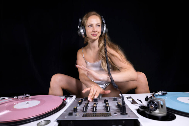Beautiful female dj playing with turntables - Фото, изображение