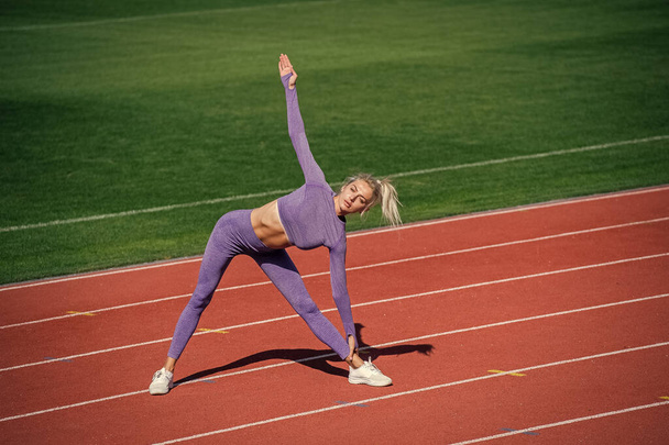 fit your body. female athlete do sport workout. trainer or coach training. perfect body shape. healthy and sporty. sexy fitness woman in sportswear. athletic lady warming up on stadium running track. - Foto, imagen