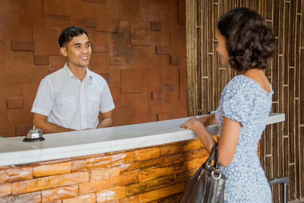 The receptionist smiles welcoming female guests to the hotel lobby - Фото, зображення