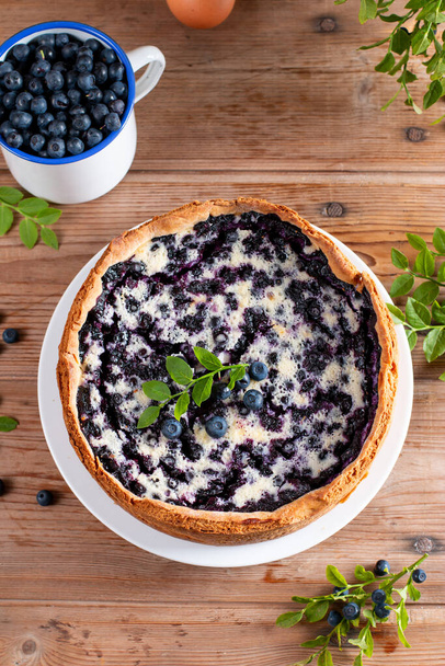 Cottage cheese casserole baked with blueberry. Curd casserole with fresh berries on kitchen table. Top view - Photo, Image