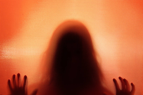 Horror ghost woman behind the matte glass. Halloween festival concept. - Photo, Image