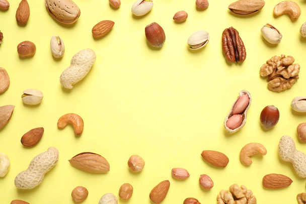 Different delicious nuts on yellow background, flat lay. Space for text - Valokuva, kuva