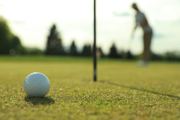 Woman playing golf at green course, focus on ball. Space for text - Fotografie, Obrázek