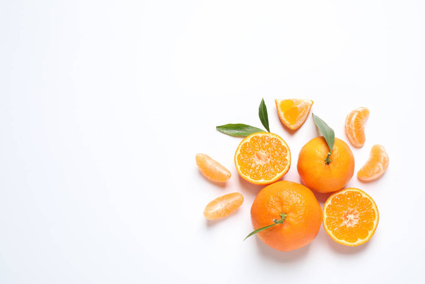Composition with fresh ripe tangerines and leaves on white background, flat lay. Citrus fruit - 写真・画像