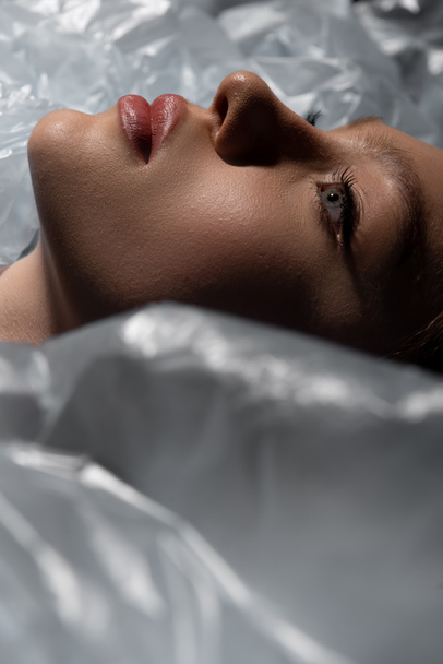 close up of teenage model lying around plastic bags, recycle fashion concept - Фото, зображення