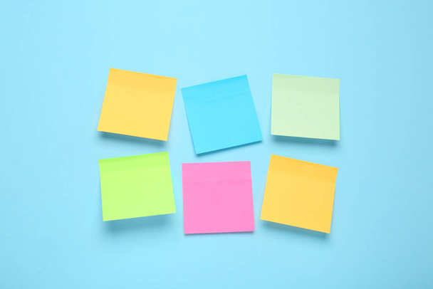 Blank colorful sticky notes on turquoise background, flat lay. Space for text - Φωτογραφία, εικόνα
