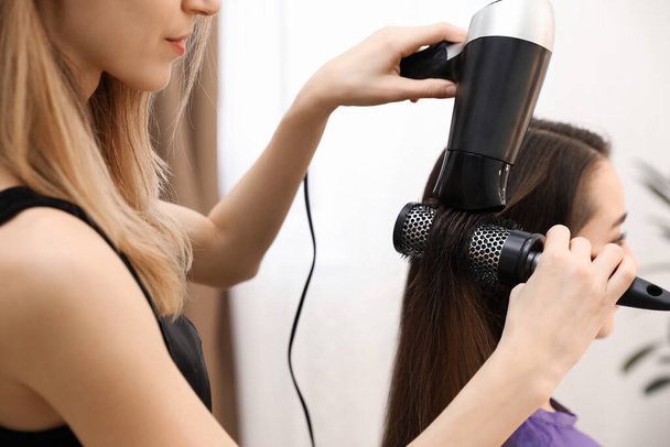 Stylist szárítás ügyfél haja szépségszalonban, közelkép - Fotó, kép