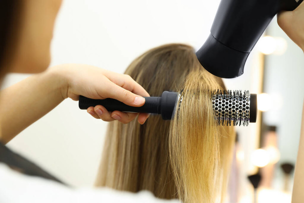 Stylist drying client's hair in beauty salon, closeup - Фото, зображення