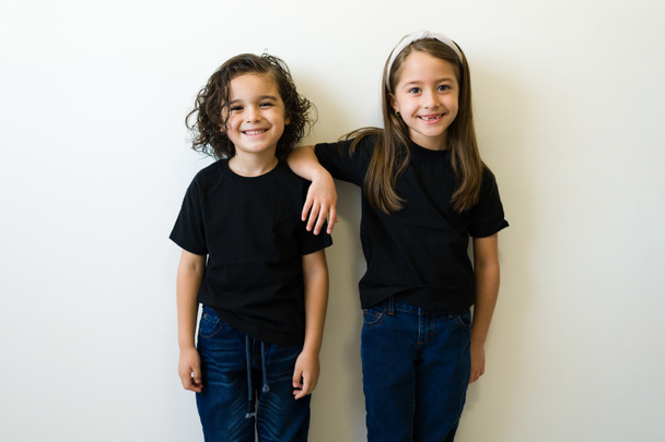 Portrait of two caucasian children friends looking at the camera and posing wearing mockup black casual t-shirts - Fotoğraf, Görsel