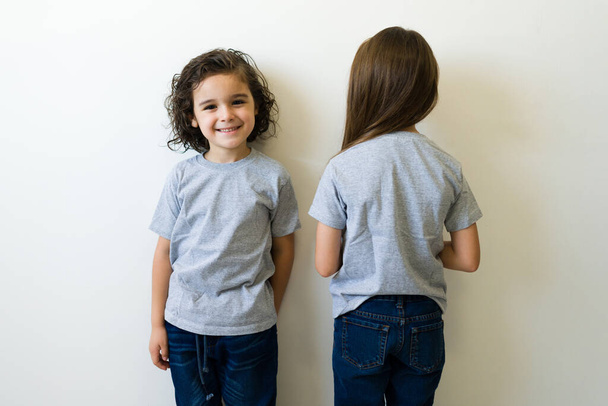 Милі кавказькі діти з сірими сорочками. Передній і задній вигляд футболки макету для дизайну друку або логотипу у хлопчика і дівчинки
 - Фото, зображення