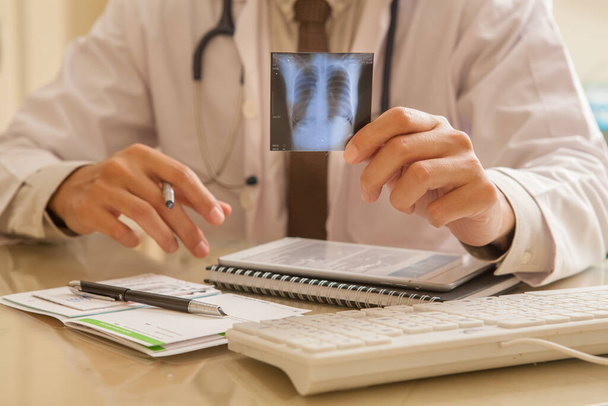 Médico examinando una radiografía pulmonar
 - Foto, imagen