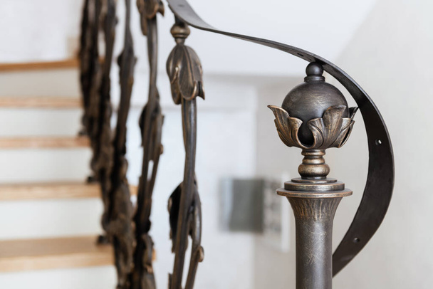 wooden stairs with metal wrought iron railings in a new house - 写真・画像