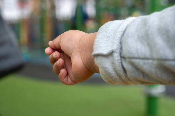 Close up view of childs outstretched hand reaching for something or someone in an outdoor setting.  - Foto, Imagem