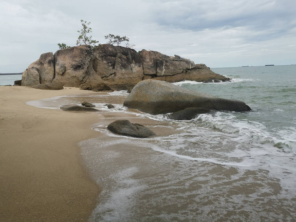 daytime scene of boulders along the beach. - Foto, imagen