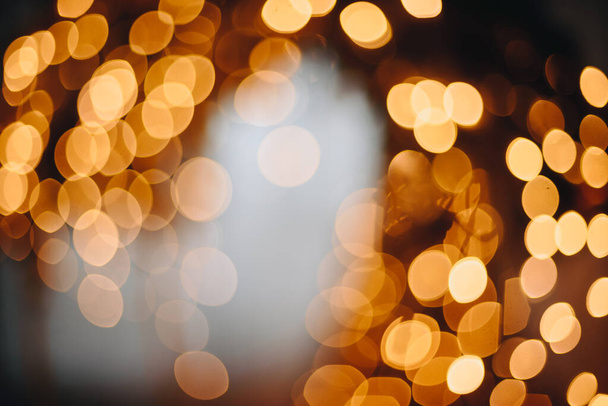 Fond abstrait de lumières chatoyantes avec des lumières bokeh dorées et jaunes déconcentrées. Saint Valentin, fête, fond de Noël. - Photo, image