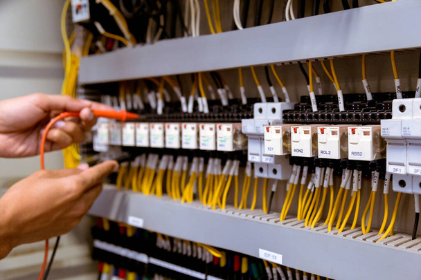 Misure dell'elettricista con test multimetro corrente elettrica nel pannello di controllo. - Foto, immagini