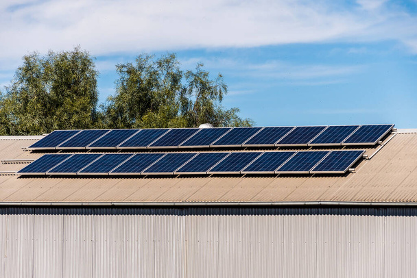 Solar panels on the roof of industrial building warehouse. Renewable solar energy concept - Foto, Imagem