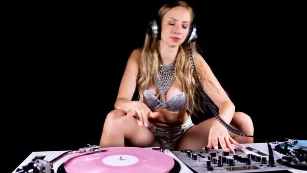 Beautiful female dj playing with turntables in sparkling silver costume - Felvétel, videó