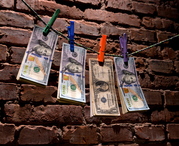 Contas de dólar penduradas em uma corda
 - Foto, Imagem